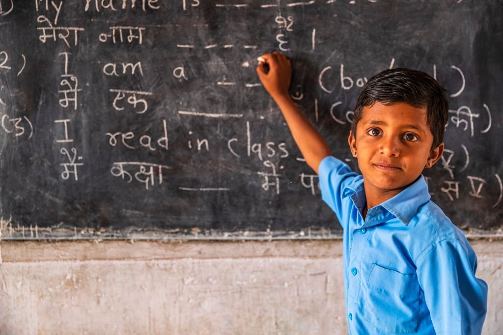 indian schoolboy in classroom, english language class, rajasthan, india